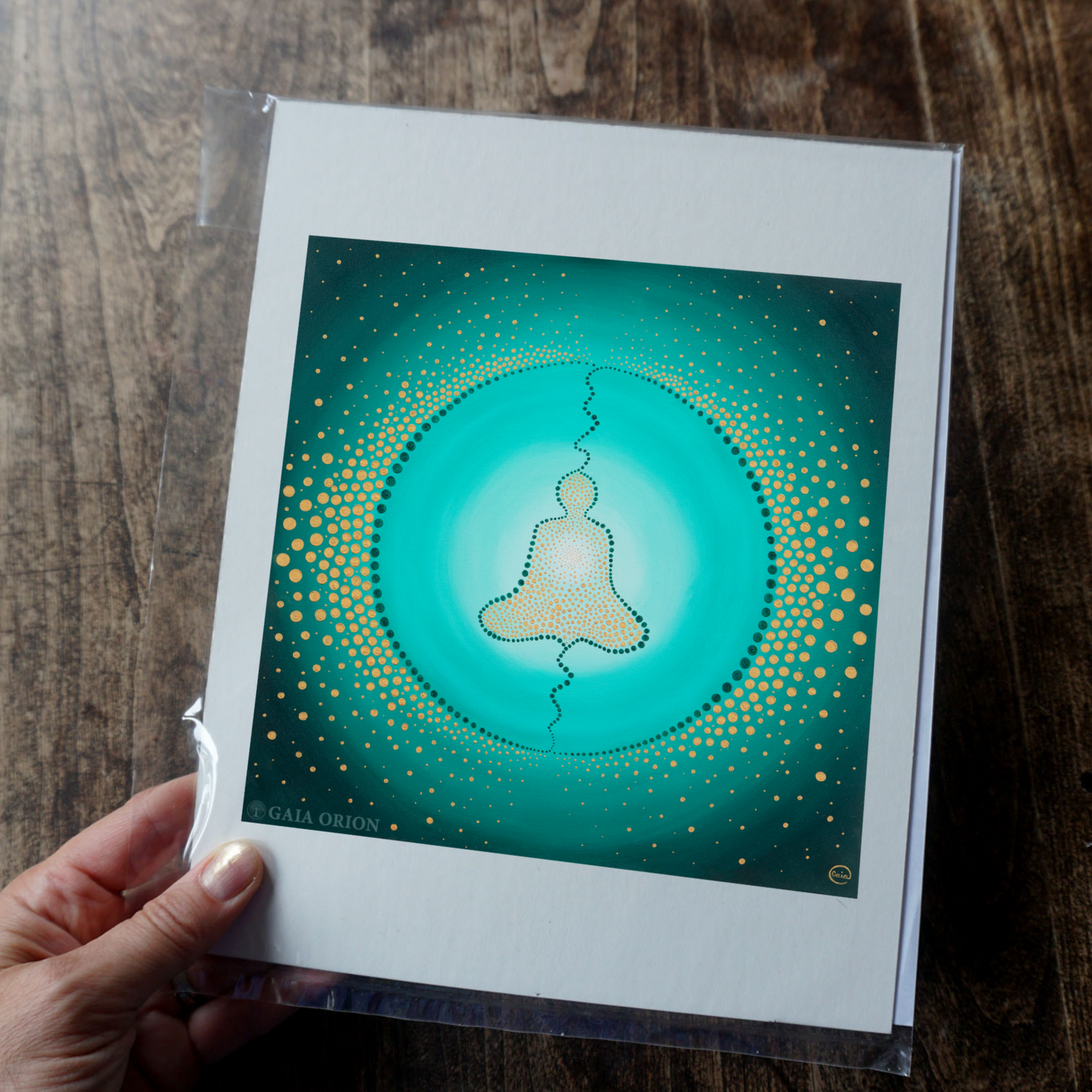A print on paper of a person meditating with light beaming from their heart