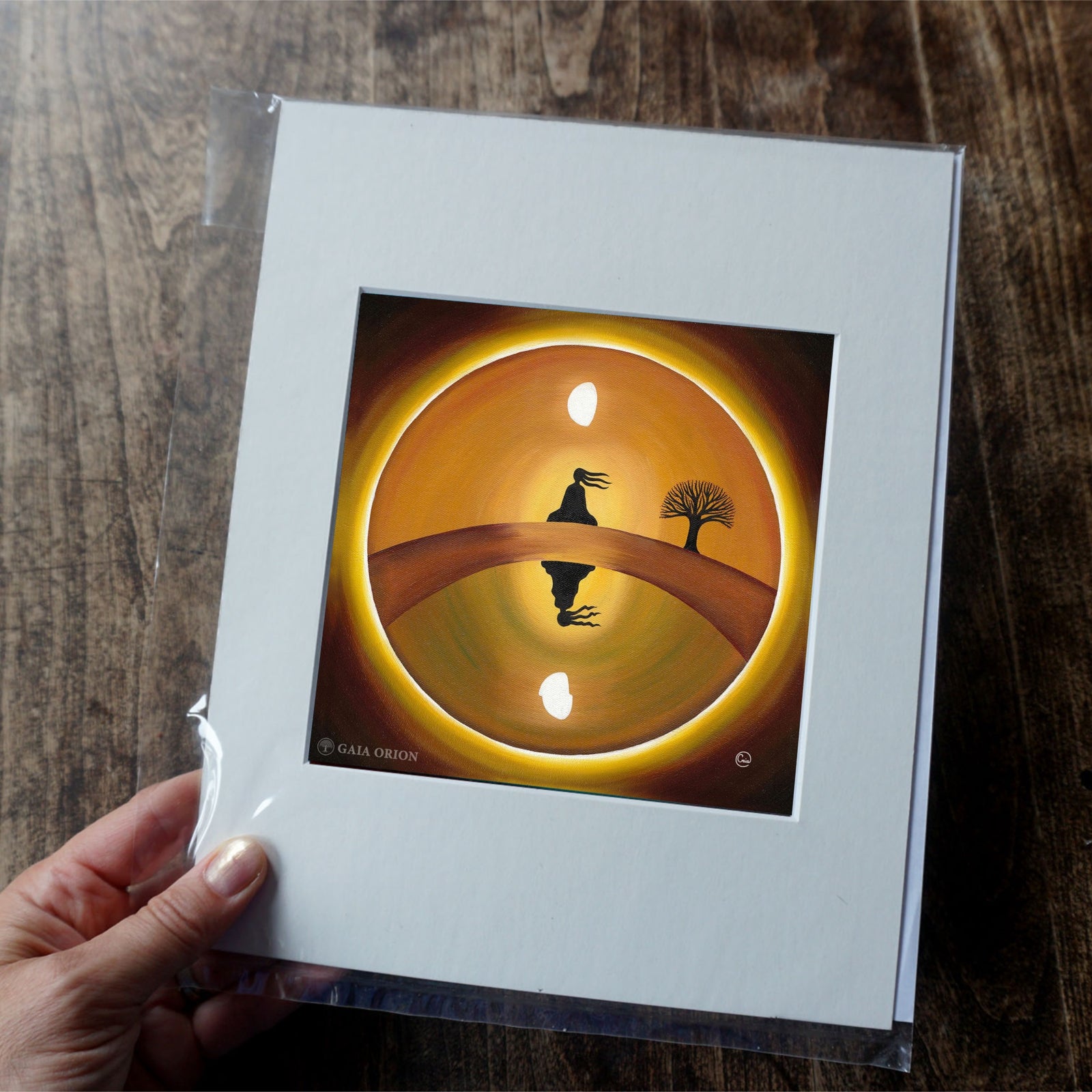 At Peace - Prints on Paper shows a meditative figure sitting on a bridge near a tree under a glowing sky.