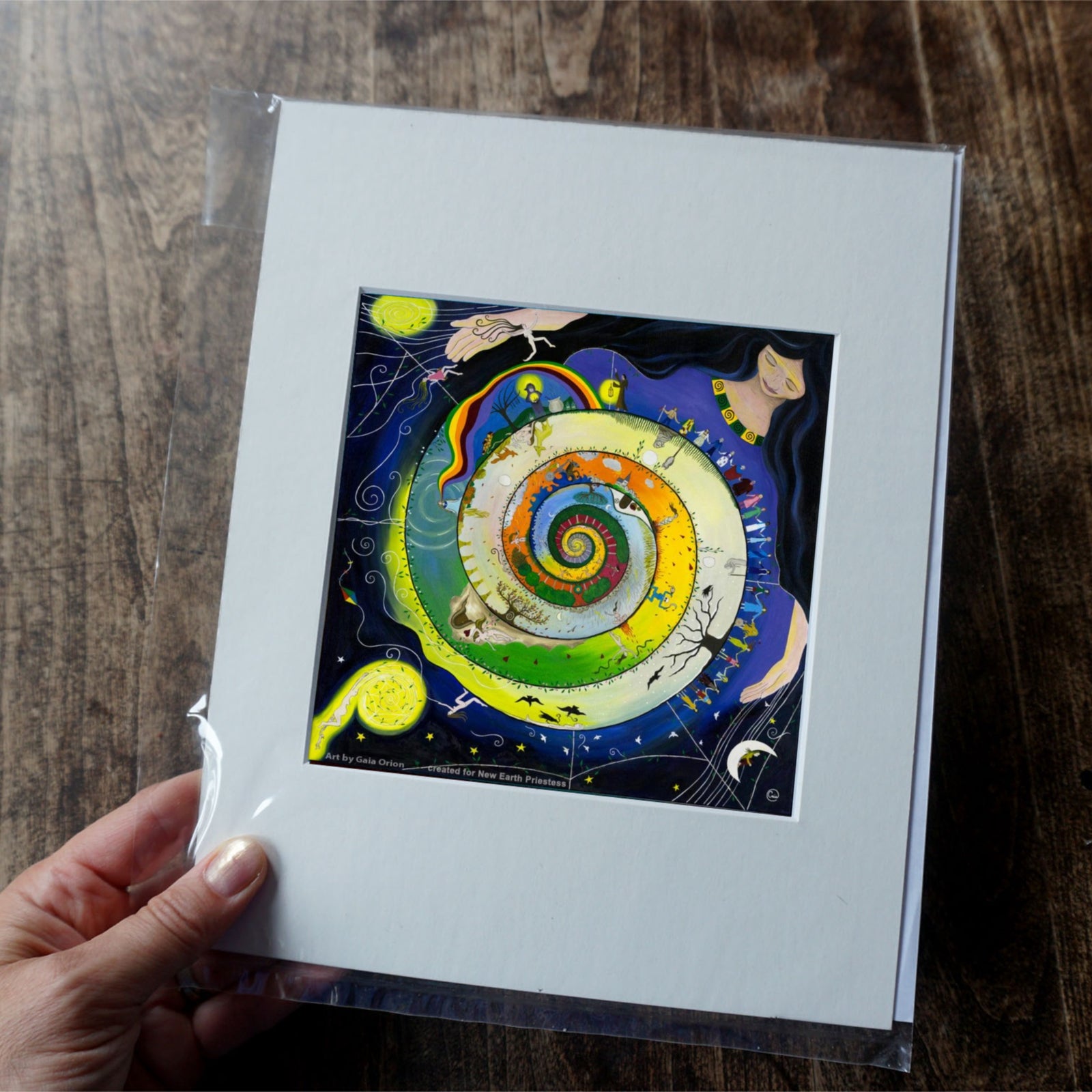 Weaving her Journey - Prints on Paper showing a woman weaving a colorful, spiral sky with diverse figures and nature elements.
