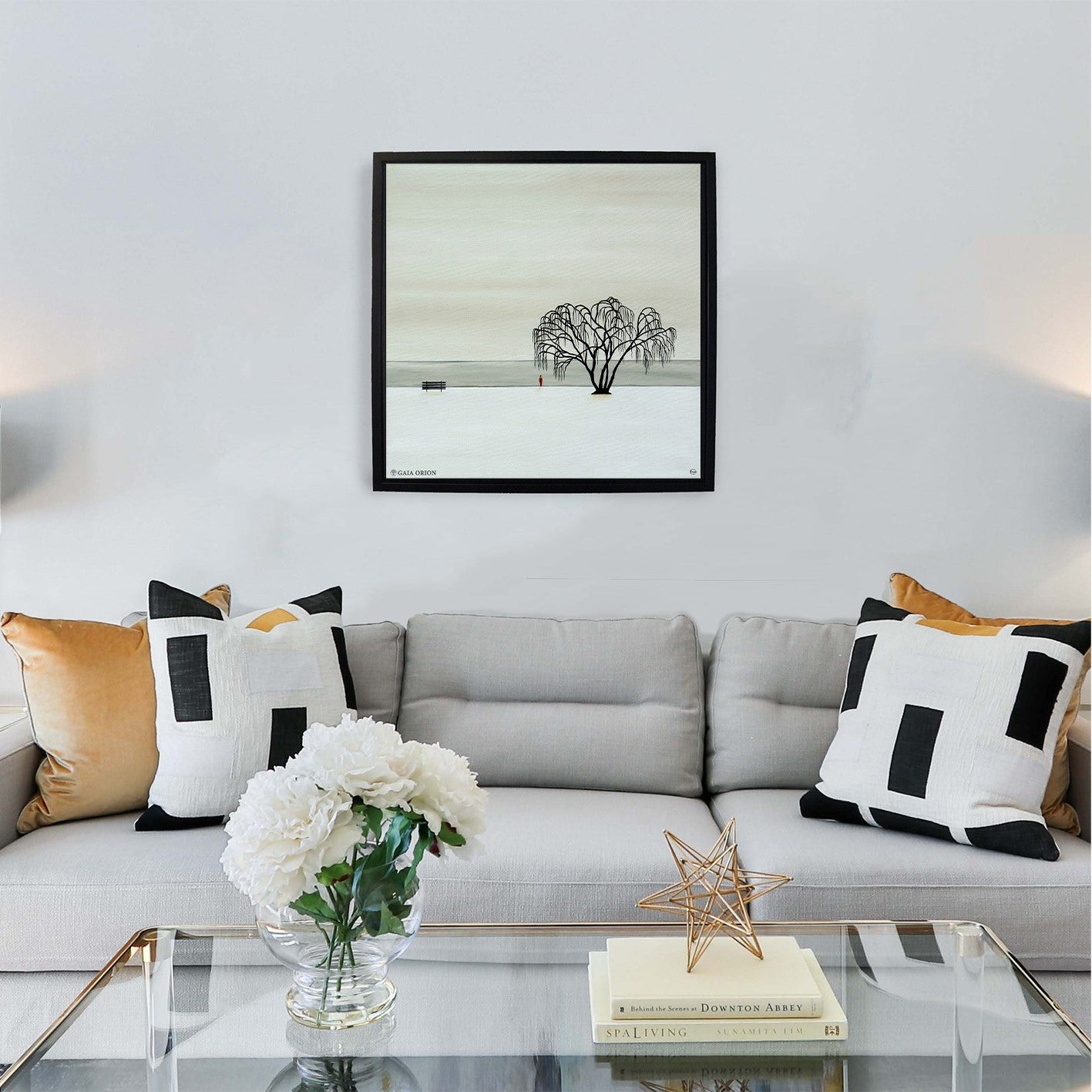 A framed print that is all white with snow and a willow tree a peaceful painting